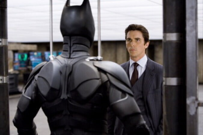 Bruce Wayne stares intently at his Batman suit.