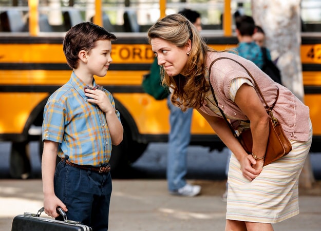 Zoe Perry and Iain Armitage standing in front a school bus in the pilot Young Sheldon episode.